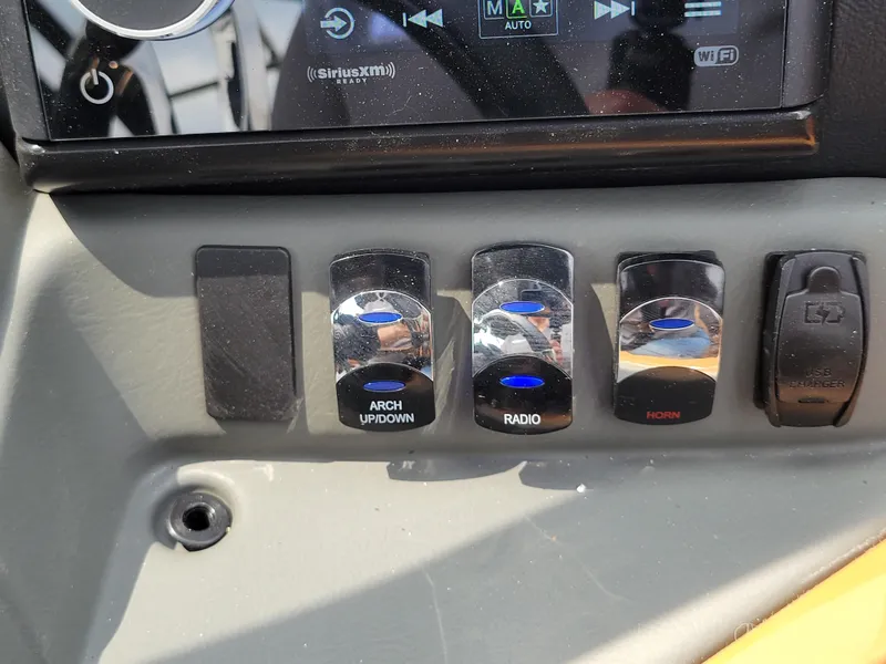 Slide: The Image of Control panel of 2024 Avalon Excalibur WQL 27 Tri-Toon boat with radio and horn switches. - 22