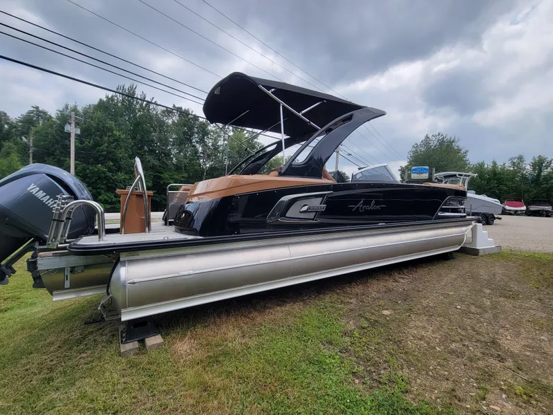 Slide: The Image of 2024 Avalon Excalibur WQL 27 Tri-Toon boat on display outdoors. - 4