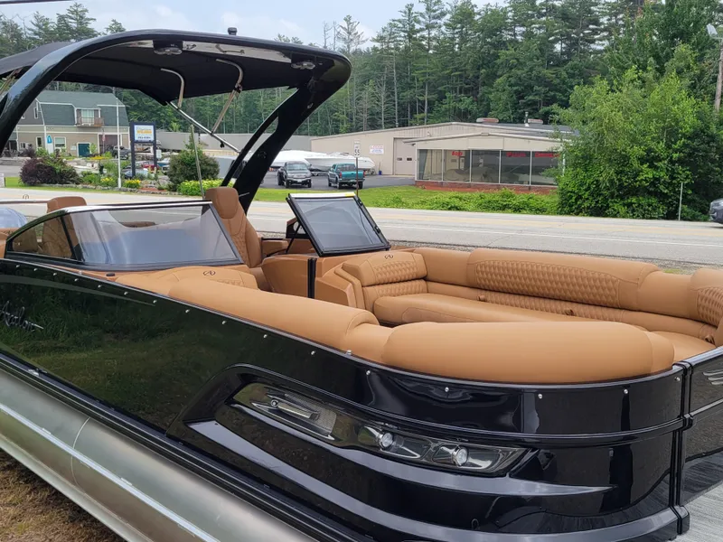 Slide: The Image of 2024 Avalon Excalibur WQL 27 Tri-Toon boat with luxurious tan seating and sleek black exterior. - 5