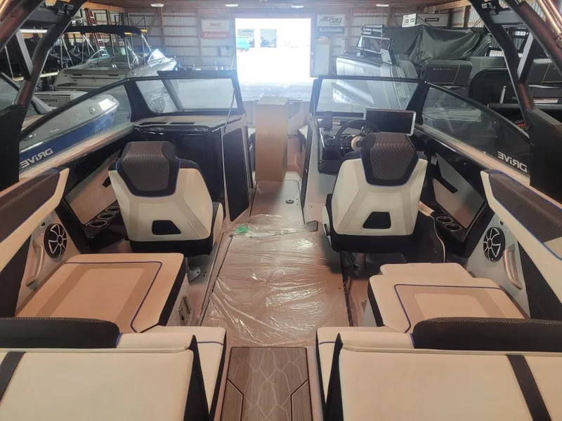 Slide: The Image of 2023 Yamaha Boats 222XD interior with modern seating and dashboard in a showroom. - 4