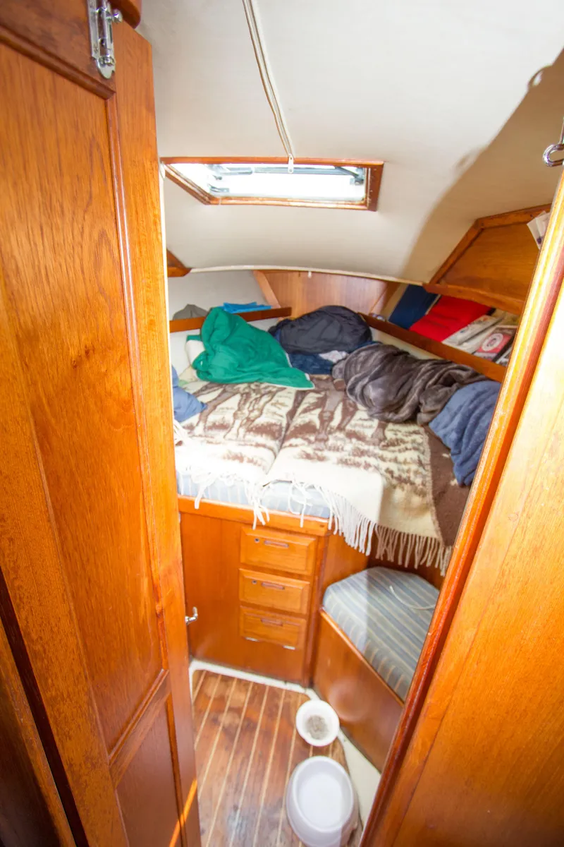 Slide: The Image of Cozy cabin interior of 1987 Ericson Mk III sloop with wooden furnishings and bedding. - 8
