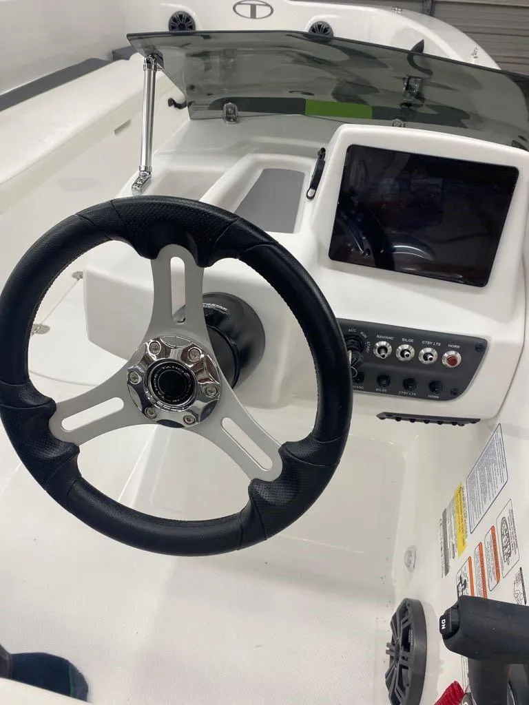 Slide: The Image of 2024 Tahoe T18 boat dashboard with steering wheel and control panel. - 1