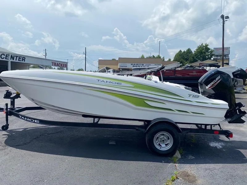 Slide: The Image of 2024 Tahoe T18 boat with green accents on a trailer, parked outdoors. - 5