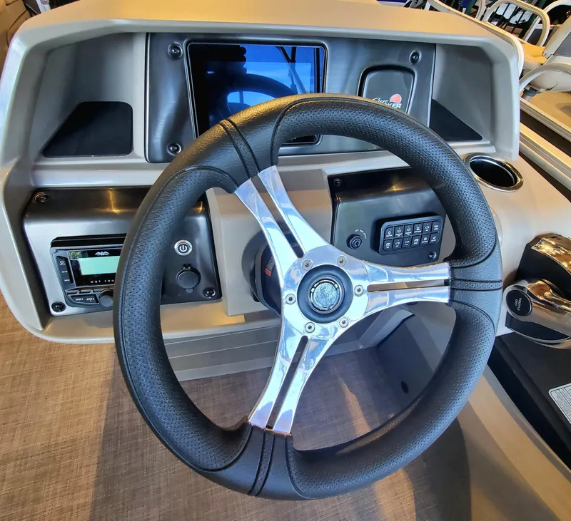 Slide: The Image of 2024 Sun Tracker SportFish 22 DLX pontoon boat on trailer with canopy. - 3