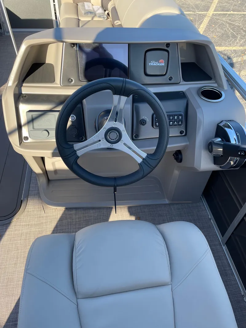 Slide: The Image of 2024 Sun Tracker Party Barge 22 XP3 boat dashboard and steering wheel. - 2