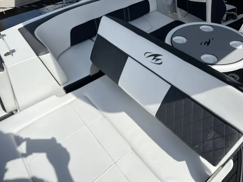 Slide: The Image of 2022 Monterey M-45 boat interior with white and black seating and cup holders. - 20