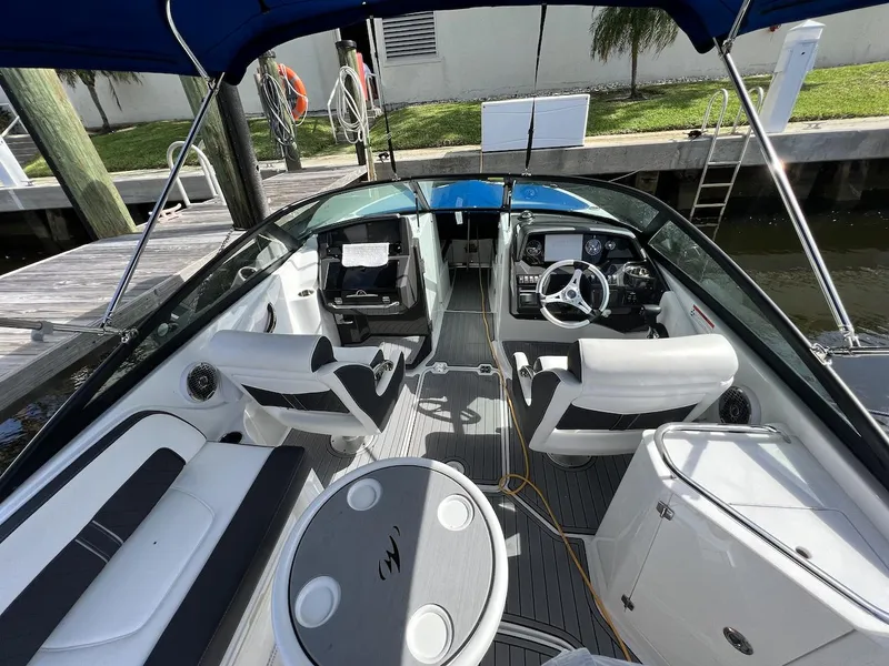 Slide: The Image of 2022 Monterey M-45 boat interior with white seating, steering wheel, and table. - 9