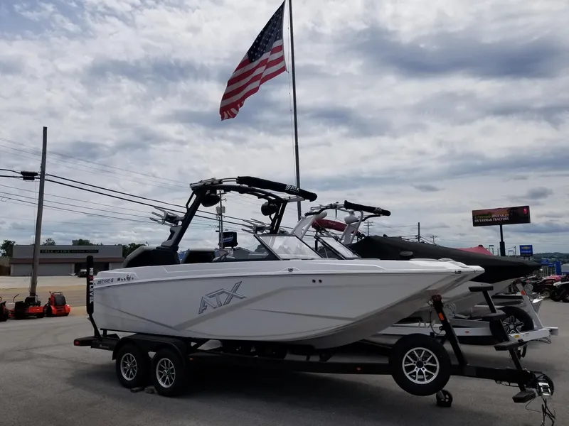 Slide: The Image of 2023 ATX Surf Boats 20 Type-S on trailer, American flag in background. - 2