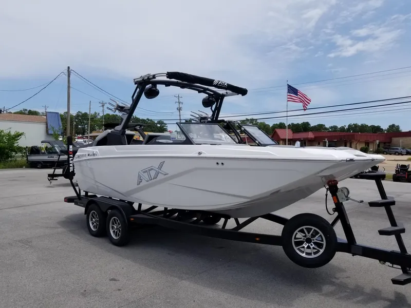 Slide: The Image of 2023 ATX Surf Boats 20 Type-S on trailer, white exterior, American flag in background. - 6