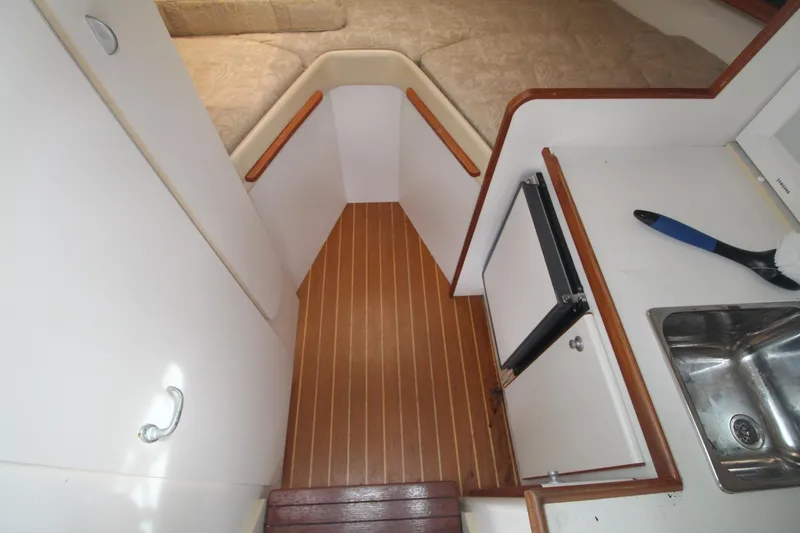 Slide: The Image of 2001 Tiara Yachts 2900 Coronet cabin interior with wood flooring and compact kitchenette. - 18