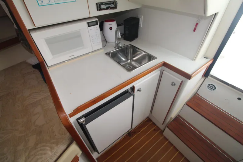 Slide: The Image of 2001 Tiara Yachts 2900 Coronet galley with microwave, sink, and compact refrigerator. - 22