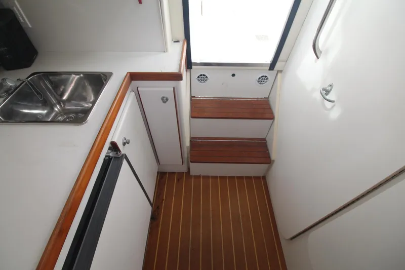Slide: The Image of 2001 Tiara Yachts 2900 Coronet interior with wooden steps, sink, and cabinetry. - 23
