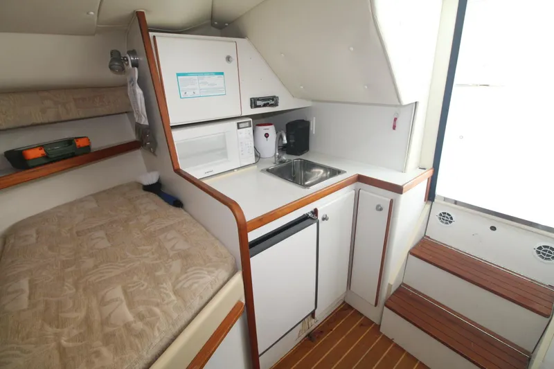 Slide: The Image of 2001 Tiara Yachts 2900 Coronet interior with kitchenette, bed, and wooden steps. - 24