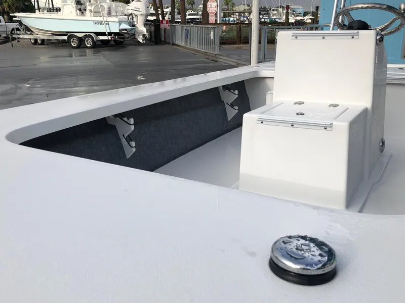 Slide: The Image of 2025 Mitzi Skiffs 17 boat interior with console and seating, docked at marina. - 11