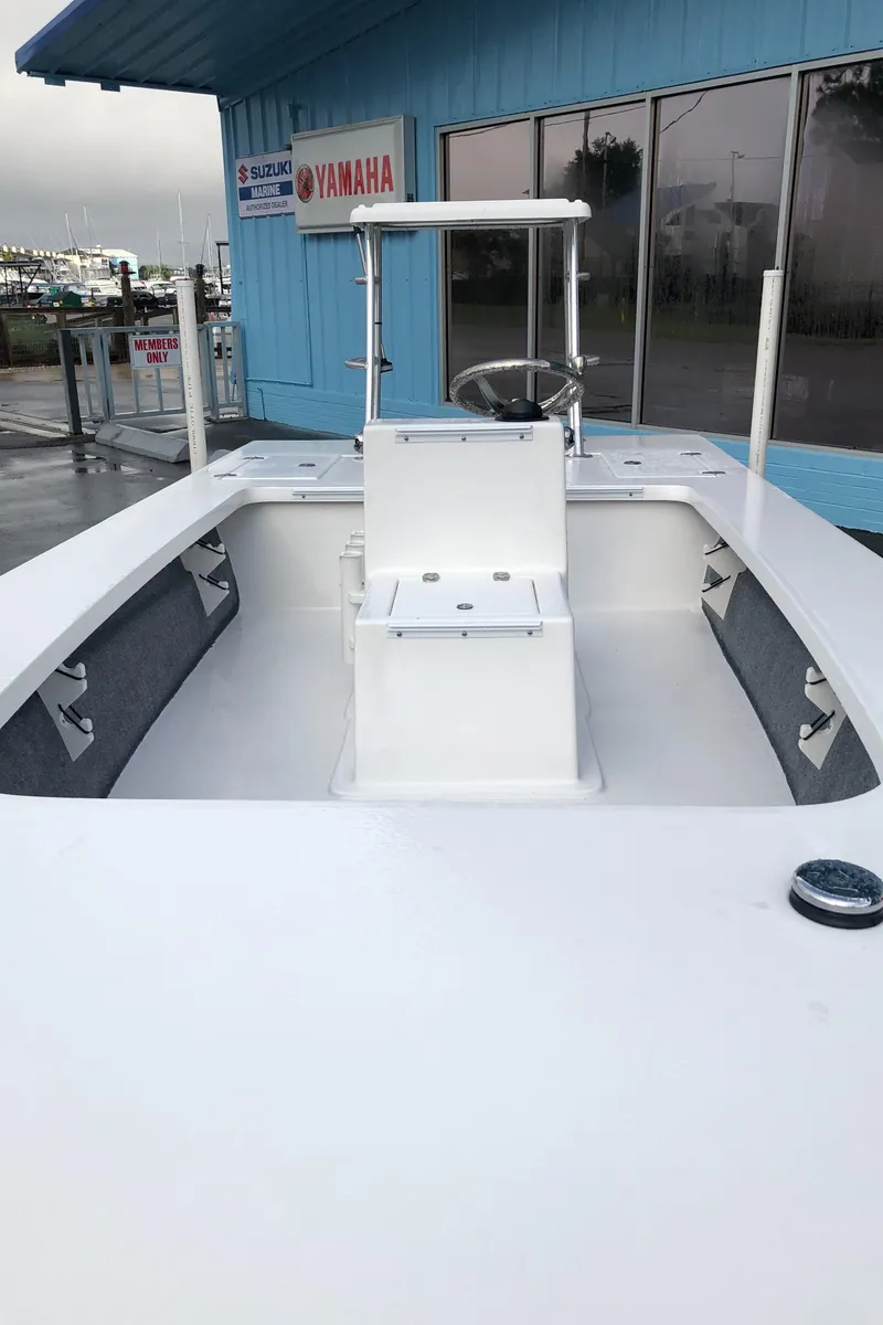 Slide: The Image of 2025 Mitzi Skiffs 17 boat at marina, featuring sleek white design and spacious deck. - 18