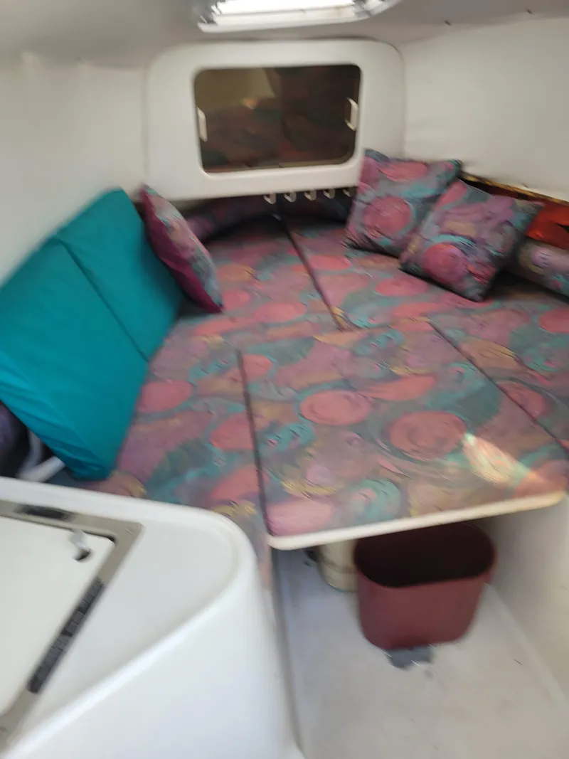 Slide: The Image of 1996 Pro-Line 231 Walk Around Cuddy cabin interior with colorful cushions. - 12