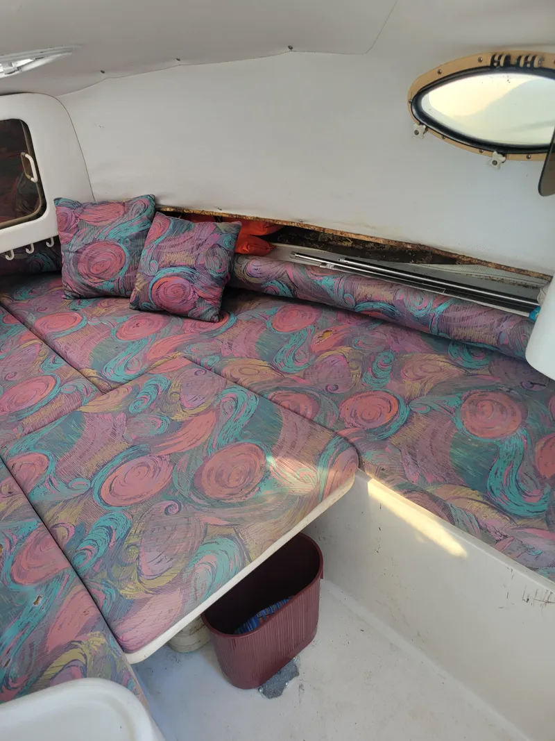 Slide: The Image of 1996 Pro-Line 231 Walk Around Cuddy cabin with colorful patterned cushions. - 13