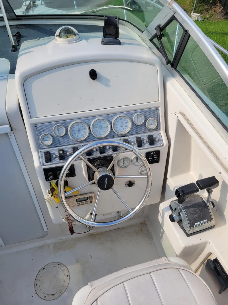 Slide: The Image of 1996 Pro-Line 231 Walk Around Cuddy boat dashboard and steering wheel. - 14