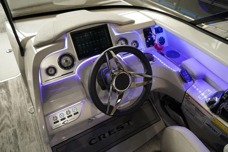 Slide: The Image of 2024 Crest Continental 250 SLS CP3 boat dashboard with illuminated controls and modern steering wheel. - 10