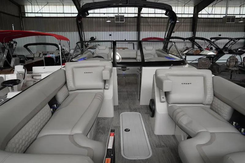 Slide: The Image of 2024 Crest Continental 250 SLS CP3 boat interior with luxurious seating in a showroom. - 17
