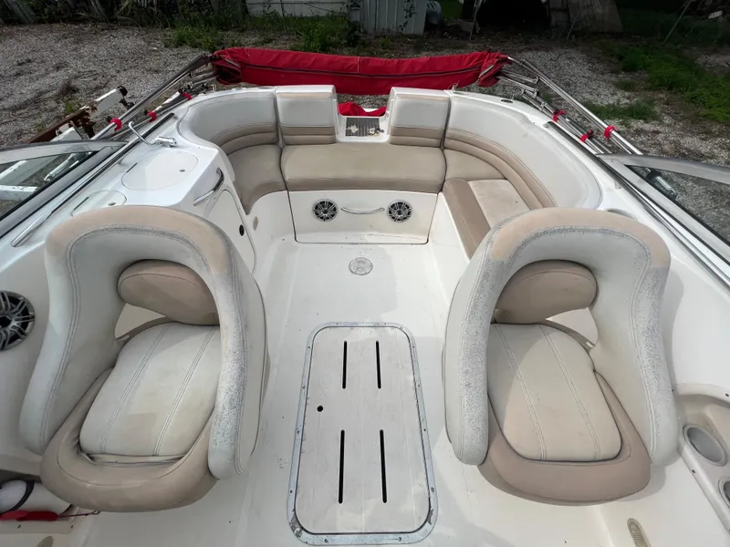 Slide: The Image of Interior of a 2004 Bryant 234 boat with beige seating and white deck. - 13