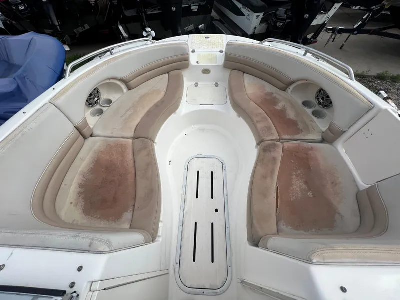 Slide: The Image of 2004 Bryant 234 boat interior with worn seating and cup holders. - 4