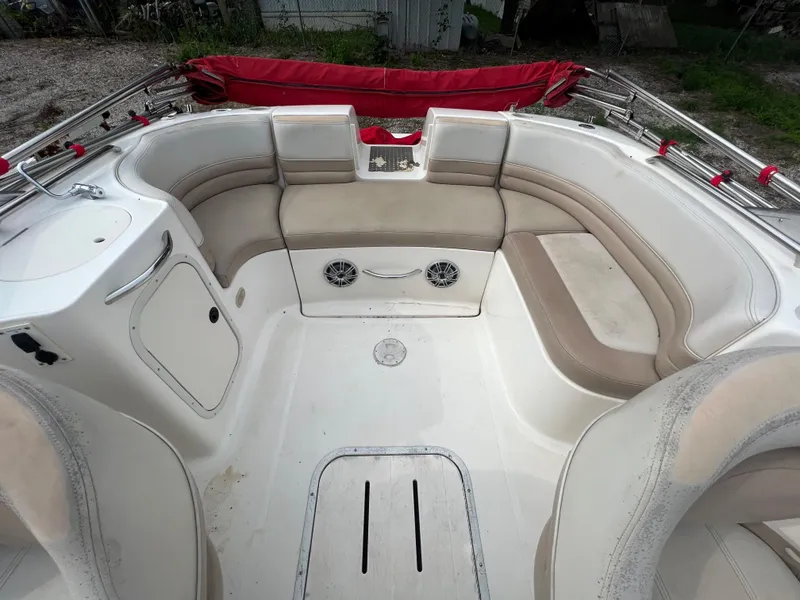 Slide: The Image of 2004 Bryant 234 boat interior with beige seating and red canopy. - 9