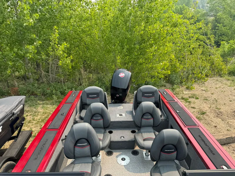 Slide: The Image of 2023 Tracker Targa V-18 WT boat interior with seating, surrounded by lush greenery. - 13
