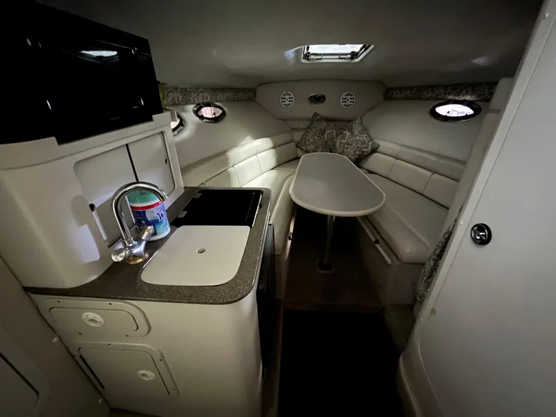 Slide: The Image of Interior of 2000 Crownline 242 CR boat with kitchenette and seating area. - 14