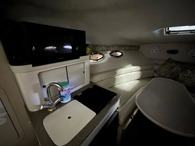 Slide: The Image of Interior of 2000 Crownline 242 CR boat with kitchenette and seating area. - 15