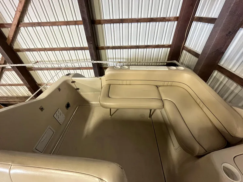 Slide: The Image of 2000 Crownline 242 CR boat interior with beige seating in a storage facility. - 7