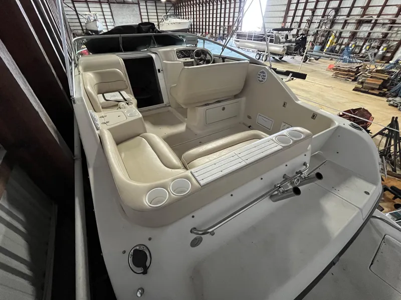 Slide: The Image of 2000 Crownline 242 CR boat interior with beige seating and control panel in storage facility. - 8