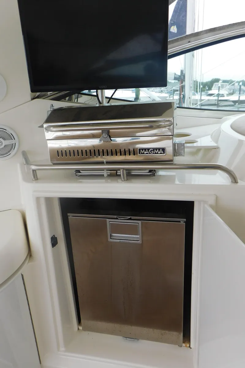 Slide: The Image of Outdoor kitchen area on 2005 Cruisers Yachts 520 Express with grill and refrigerator. - 10