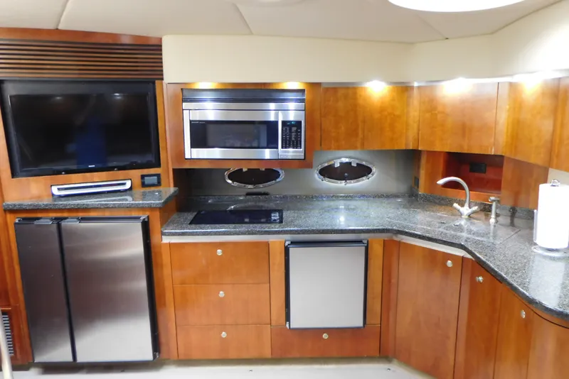 Slide: The Image of 2005 Cruisers Yachts 520 Express kitchen with modern appliances and sleek wooden cabinetry. - 25