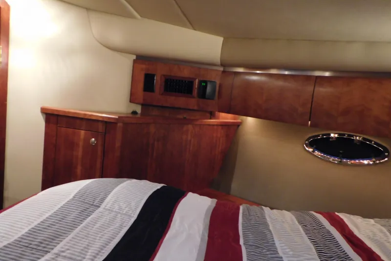 Slide: The Image of Interior cabin of 2005 Cruisers Yachts 520 Express with wood cabinetry and striped bedding. - 31
