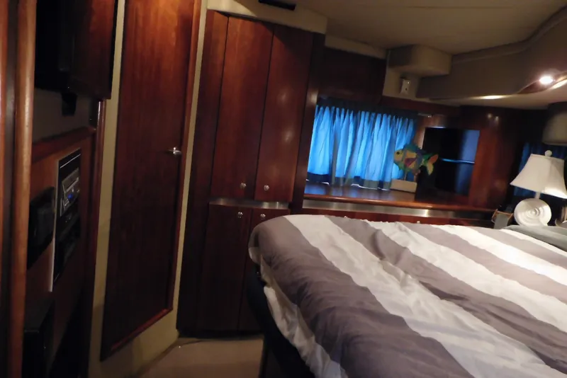 Slide: The Image of Luxurious cabin interior of 2005 Cruisers Yachts 520 Express with wood paneling and cozy bedding. - 38
