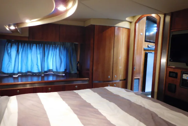 Slide: The Image of Luxurious cabin interior of 2005 Cruisers Yachts 520 Express with wood finish and blue curtains. - 39