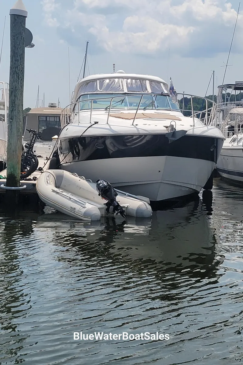 Slide: The Image of 2005 Cruisers Yachts 520 Express docked with inflatable boat in marina. - 4