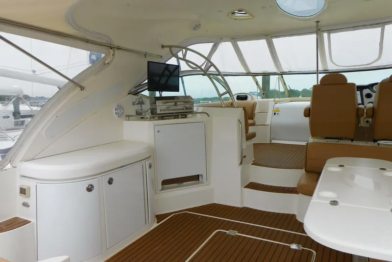Slide: The Image of 2005 Cruisers Yachts 520 Express interior with seating, TV, and wooden flooring. - 8