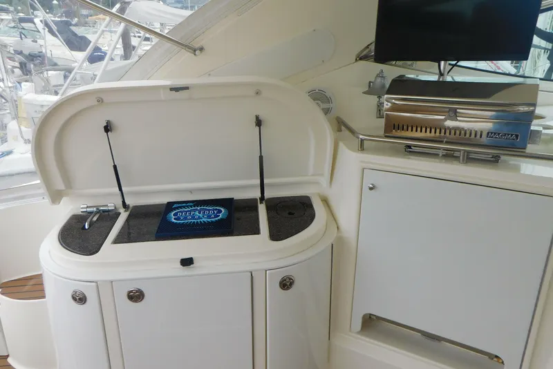 Slide: The Image of 2005 Cruisers Yachts 520 Express interior with grill and storage compartments. - 9