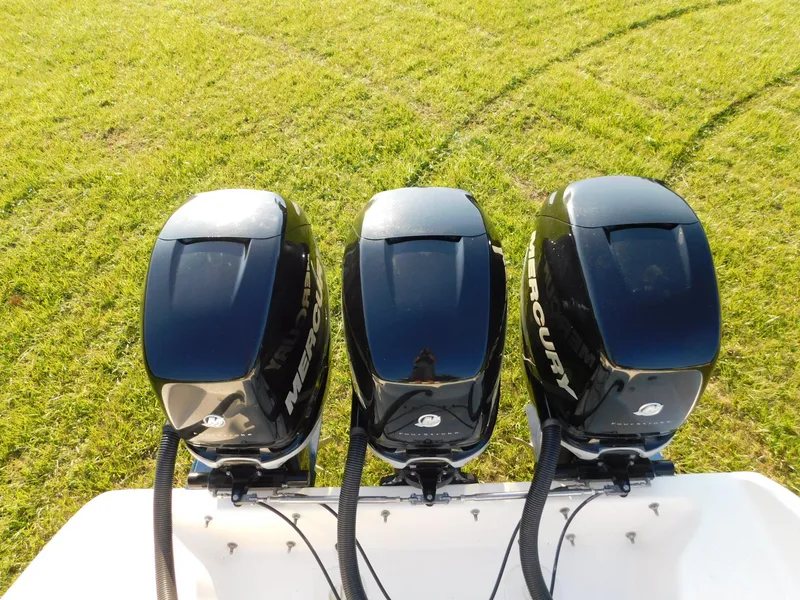 Slide: The Image of Three Mercury outboard motors on a Solid Craft LIMITED 40 boat, 2005 model, on grass. - 4