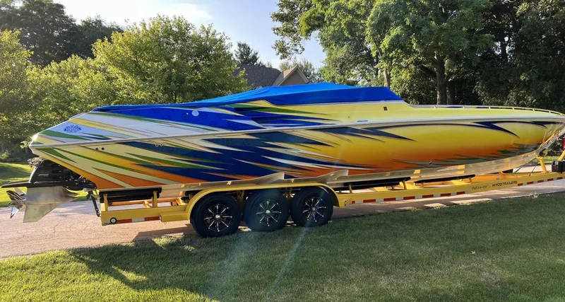 Slide: The Image of 2007 Fountain 42 Lightning speedboat with vibrant yellow and blue graphics on a trailer. - 14