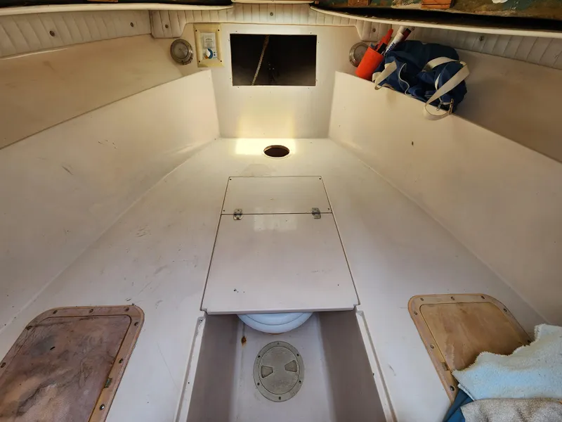 Slide: The Image of 1990 Intrepid 321 Cuddy cabin interior with storage compartments and nautical equipment. - 10
