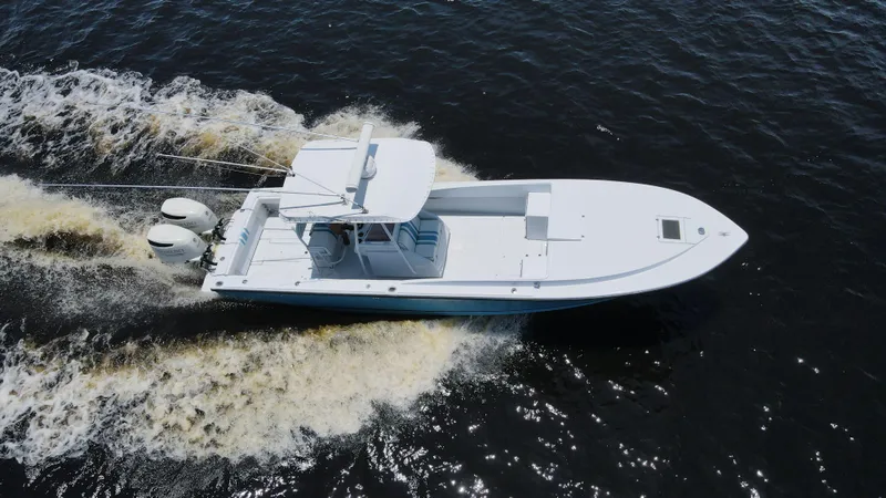 Slide: The Image of Aerial view of a 1990 Intrepid 321 Cuddy boat cruising on water. - 11