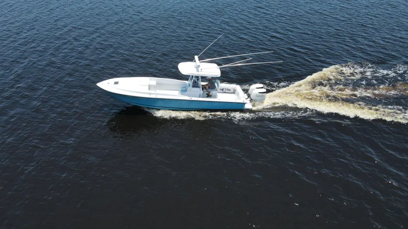 Slide: The Image of Aerial view of 1990 Intrepid 321 Cuddy boat cruising on open water. - 12