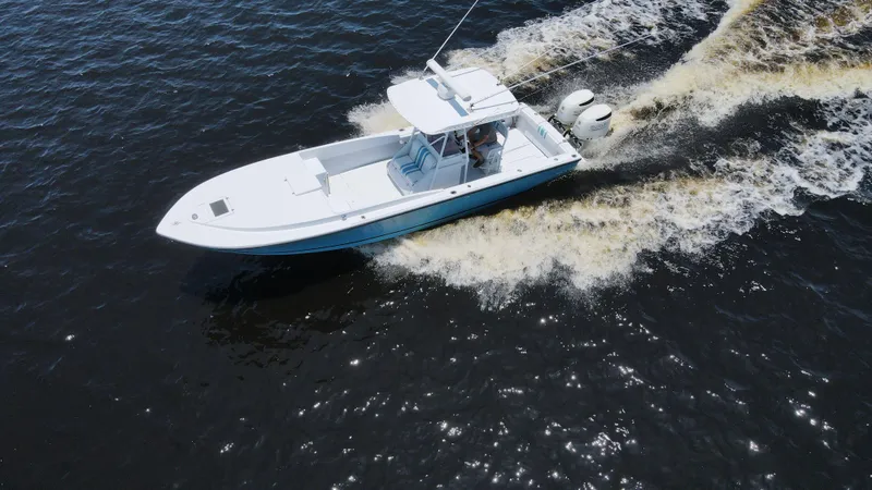 Slide: The Image of Aerial view of 1990 Intrepid 321 Cuddy boat cruising on water. - 14