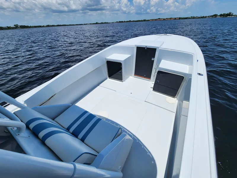 Slide: The Image of 1990 Intrepid 321 Cuddy boat on calm water, clear sky background. - 5