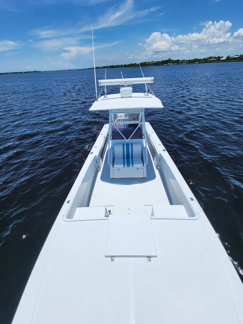 Slide: The Image of 1990 Intrepid 321 Cuddy boat on open water under a clear blue sky. - 6