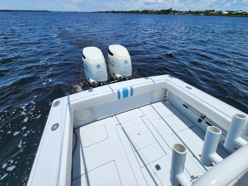Slide: The Image of 1990 Intrepid 321 Cuddy boat with twin outboard engines on open water. - 8