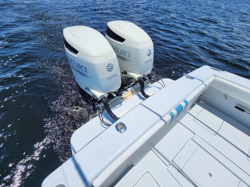 Slide: The Image of 1990 Intrepid 321 Cuddy with twin Suzuki outboard motors on the water. - 9